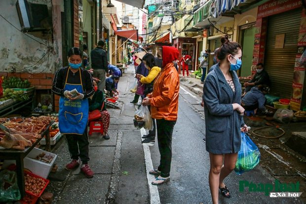 Đủ cách sáng tạo ở chợ mùa Covid-19: Người bán lập hàng rào nilon, đeo micro khi nói chuyện với khách - Ảnh 3.