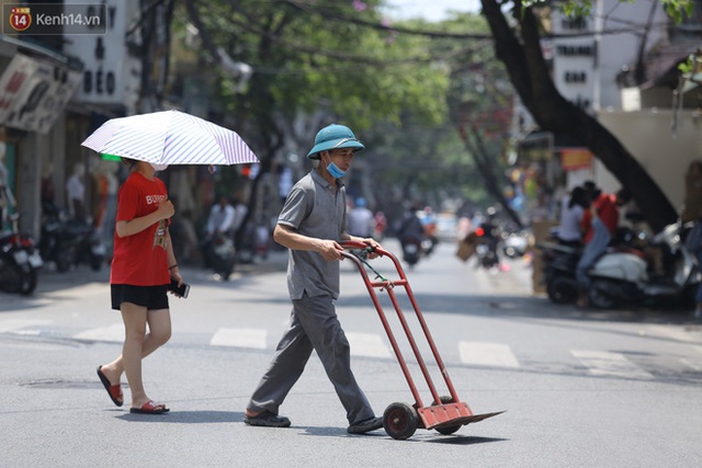 Ảnh: Người dân Thủ đô vật vã chống chọi với nắng nóng kinh hoàng, trùm cả mảnh vải hay đội khăn ướt để giải nhiệt - Ảnh 12.