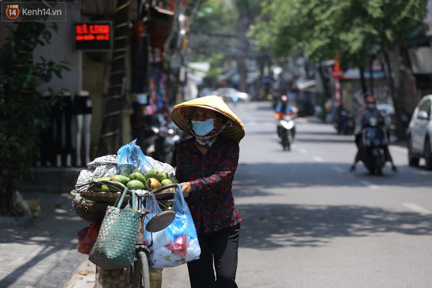 Ảnh: Người dân Thủ đô vật vã chống chọi với nắng nóng kinh hoàng, trùm cả mảnh vải hay đội khăn ướt để giải nhiệt - Ảnh 7.