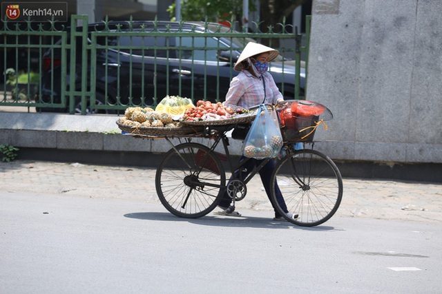 Ảnh: Người dân Thủ đô vật vã chống chọi với nắng nóng kinh hoàng, trùm cả mảnh vải hay đội khăn ướt để giải nhiệt - Ảnh 13.