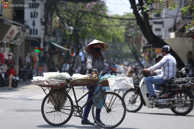 Ảnh: Người dân Thủ đô vật vã chống chọi với nắng nóng kinh hoàng, trùm cả mảnh vải hay đội khăn ướt để giải nhiệt - Ảnh 10.