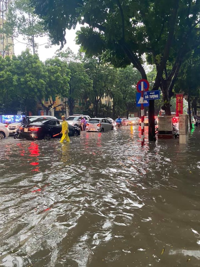 Hà Nội: Mưa to như trút nước lúc tan tầm, nhiều tuyến phố trung tâm lại biến thành sông - Ảnh 2.