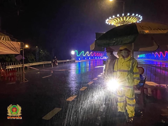 Bão về, các chiến sĩ đu người bám lấy các thanh sắt để không bay chốt kiểm dịch làm dân mạng xót xa - Ảnh 1.